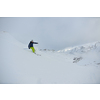 skier skiing downhill on fresh powder snow  with sun and mountains in background