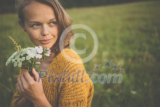 Beautiful young woman outdoors with a bouquet of wild flowers in a field, enjoying nature. Happy Woman on spring meadow Beautiful young woman outdoors with a bouquet of wild flowers in a field, enjoying nature. Happy Woman on spring meadow