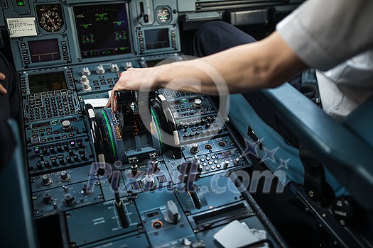 Pilot's hand accelerating on the throttle in a commercial airliner airplane flight cockpit during takeoff Pilot's hand accelerating on the throttle in a commercial airliner airplane flight cockpit during takeoff