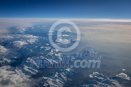 View from a cockpit of a commercial airliner airplane over a beautiful mountain range View from a cockpit of a commercial airliner airplane over a beautiful mountain range