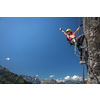 Pretty, female climber on a via ferrata - climbing on a rock in Swiss Alps