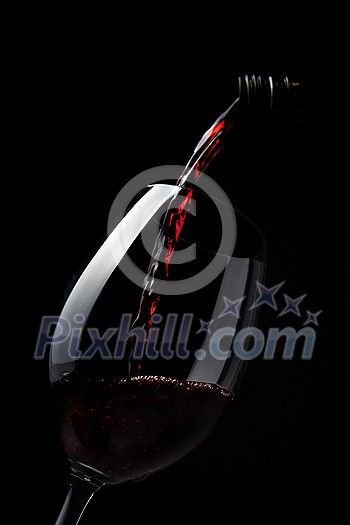 Red wine pouring into wine glass on dark background - lovely, rich, full bodied, ruby coloured, Shiraz