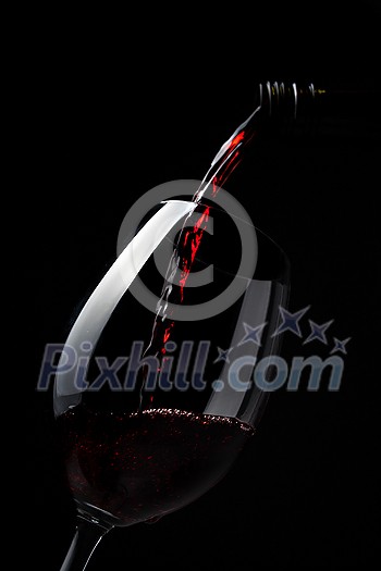 Red wine pouring into wine glass on dark background - lovely, rich, full bodied, ruby coloured, Shiraz Red wine pouring into wine glass on dark background - lovely, rich, full bodied, ruby coloured, Shiraz