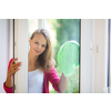 Pretty, young woman washing windows of her household. Cleaning with a detergent (shallow DOF)
