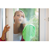 Pretty, young woman washing windows of her household. Cleaning with a detergent (shallow DOF)