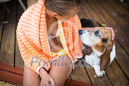Young woman with her dog by the pool, teasing him Young woman with her dog by the pool, teasing him