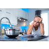 Pretty, young woman in her modern, clean and bright kitchen, thinking about what to cook for her family, looking quite desperate (color toned imagey; shallow DOF)