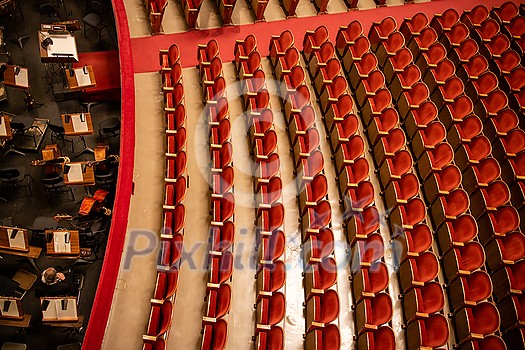 Beautiful of the empty parterre and part of the orchestra pit in the theatre concert hall of Vienna State Opera auditorium with red seats in the rows without people in Vienna, Austria.