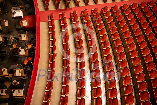 Beautiful of the empty parterre and part of the orchestra pit in the theatre concert hall of Vienna State Opera auditorium with red seats in the rows without people in Vienna, Austria. Beautiful of the empty parterre and part of the orchestra pit in the theatre concert hall of Vienna State Opera auditorium with red seats in the rows without people in Vienna, Austria.