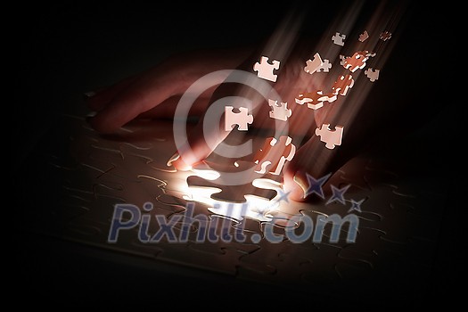 Hand connecting missing jigsaw glowing puzzle piece Hand connecting missing jigsaw glowing puzzle piece