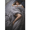 Pretty, young woman sleeping in her bed late in the morning on a weekend - compensating for the lack of sleep