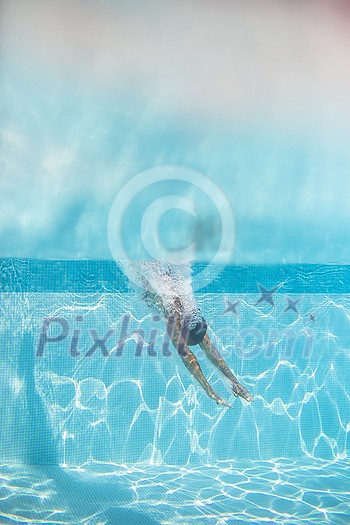 Young woman in a swimming pool performing some synchronized swimming drills