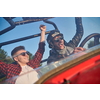 two young happy excited men enjoying beautiful sunny day while driving a off road buggy car on mountain nature