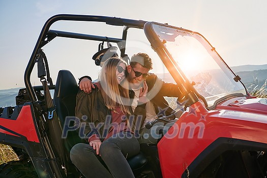 portrait of young happy excited couple enjoying beautiful sunny day while driving a off road buggy car on mountain nature