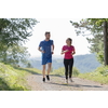 young happy couple enjoying in a healthy lifestyle while jogging on a country road through the beautiful sunny forest, exercise and fitness concept