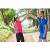 young happy couple enjoying in a healthy lifestyle while jogging on a country road through the beautiful sunny forest, exercise and fitness concept