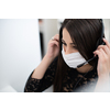 Female call center operator talking to a customer. Businesswoman in mask at the workplace in the  modern office. Social distance and safety outbreak new normal concept