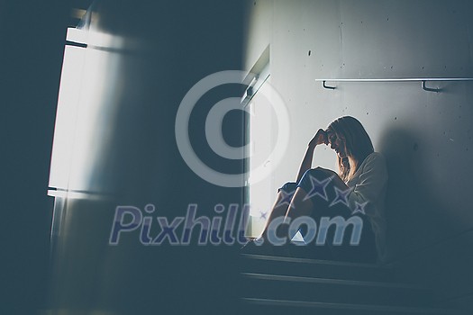 Depressed woman wearing medical face mask, looking out the window at an empty city, loss job due to coronavirus pandemic, Covid-19 outbreak. Unemployment, economic crisis, financial distress