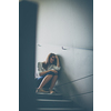 Depressed young woman sitting in a staircase, jobloss due to coronavirus pandemic, Covid-19 outbreak. Unemployment, economic crisis, financial distress concept