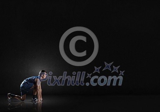 Young man athlete standing in start pose Young man athlete standing in start pose