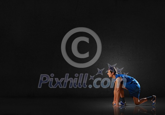 Young man athlete standing in start pose Young man athlete standing in start pose