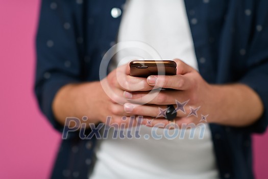 macro photo of a young man using a smartphone  on a pink background
