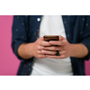 macro photo of a young man using a smartphone  on a pink background