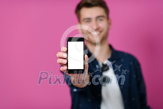 covid passport, a young man shows his code and covid passport on his cell phone while posing in front of a pink background