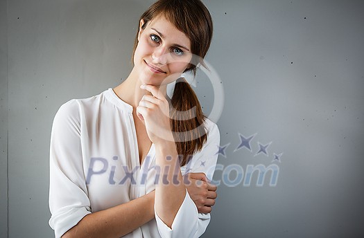Pensive young woman in casual clothing with copy space. Successful smiling woman, pondering an idea. Pensive young woman in casual clothing with copy space. Successful smiling woman, pondering an idea.