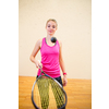 Cute young woman playing squash on a squash court, hitting the ball