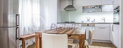 Modern Kitchen Interior Design Architecture Stock Image, Photo of a modern white kitchen with a dark wood table, hi-end appliances and plenty of daylight