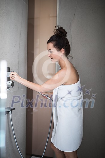Woman taking a long hot shower washing her hair in a modern design bathroom Woman taking a long hot shower washing her hair in a modern design bathroom