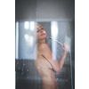 Woman taking a long hot shower washing her hair in a modern design bathroom