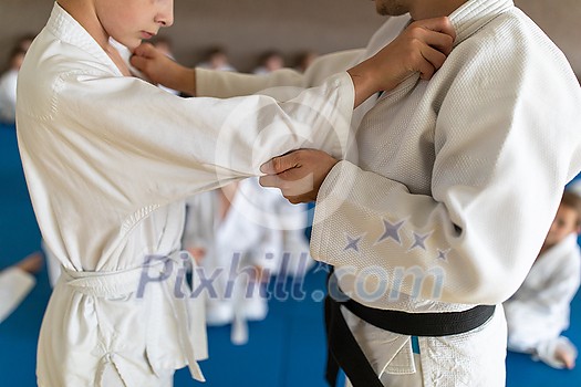 Kids in a sports hall engaged in karate drill, training, practice Kids in a sports hall engaged in karate drill, training, practice