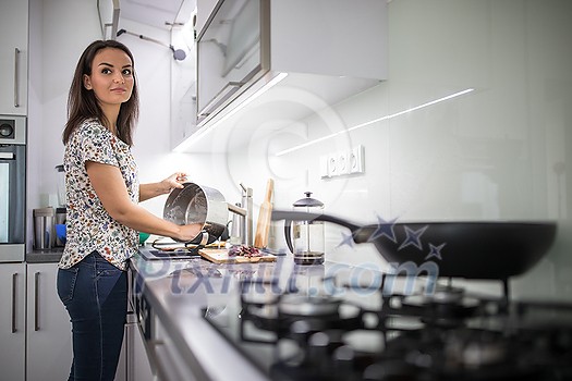 Pretty, young woman washing dishes in a modern kitchen (shallow DOF; color toned image) Pretty, young woman washing dishes in a modern kitchen (shallow DOF; color toned image)