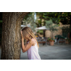 Little girl playing hide and seek with friends, counting by a tree, waiting for them to hide