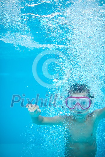 Cute little boy in a swimming pool, diving, swimming underwater, having fun Cute little boy in a swimming pool, diving, swimming underwater, having fun