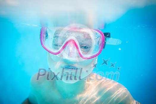 Cute little boy in a swimming pool, diving, swimming underwater, having fun Cute little boy in a swimming pool, diving, swimming underwater, having fun