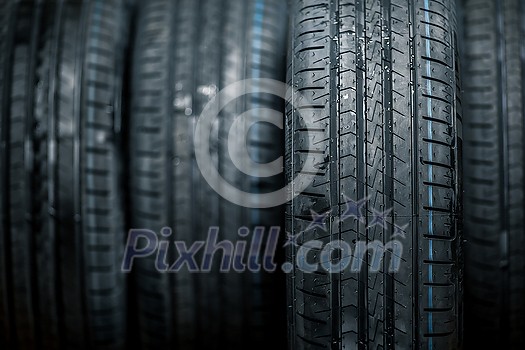 Stack of brand new high performance car tires on clean high-key white studio background