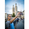 Pretty, female tourist taking selfies in front of the Grossmunster Church in Zurich, Switzerland