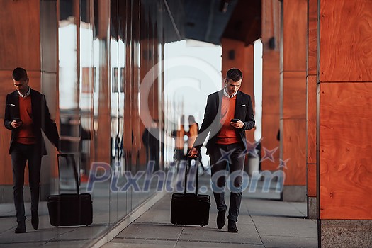 Came To Airport. Man Traveller Walking With Suitcase Outdoors And Using Smartphone. High-quality photo