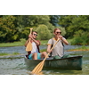 Couple adventurous explorer friends are canoeing in a wild river surrounded by the beautiful nature