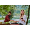 group of happy friends having picnic french dinner party outdoor during summer holiday vacation near the river at beautiful nature