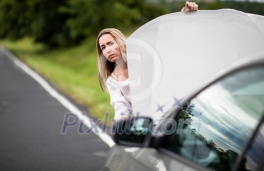 Pretty middle aged woman having car troubles - broken down car on the side of the road, calling the insurance company for assistance Pretty middle aged woman having car troubles - broken down car on the side of the road, calling the insurance company for assistance