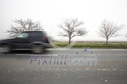 Motion blurred truck going fast on a rural road