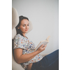 Cute young woman reading a book in a designer chair - color toned image, shallow DOF