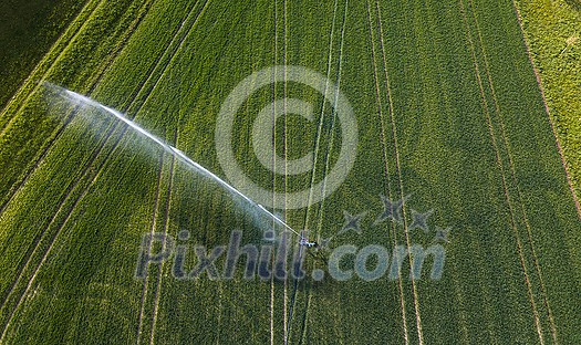 Farmland from above - aerial image of a lush green field being irrigated Farmland from above - aerial image of a lush green field being irrigated