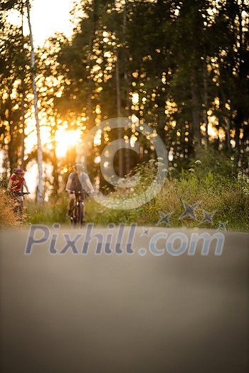 Happy couple riding bicycles outside, healthy lifestyle fun concept, taking a break admiring the view