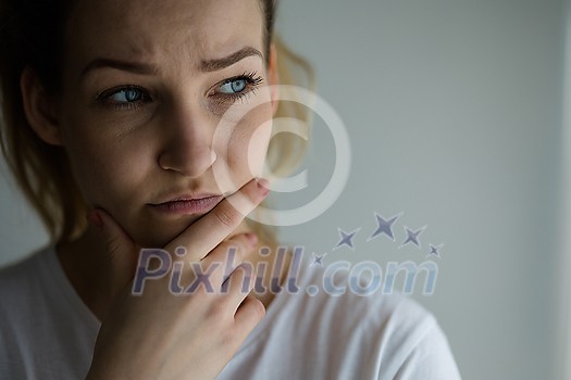 Anxious, worried, stressed young woman looking pensive, pondering, deep in thoughts.