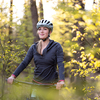 Pretty, young woman with her mountain bike going for a ride past the city limits, getting her dose of daily cardio